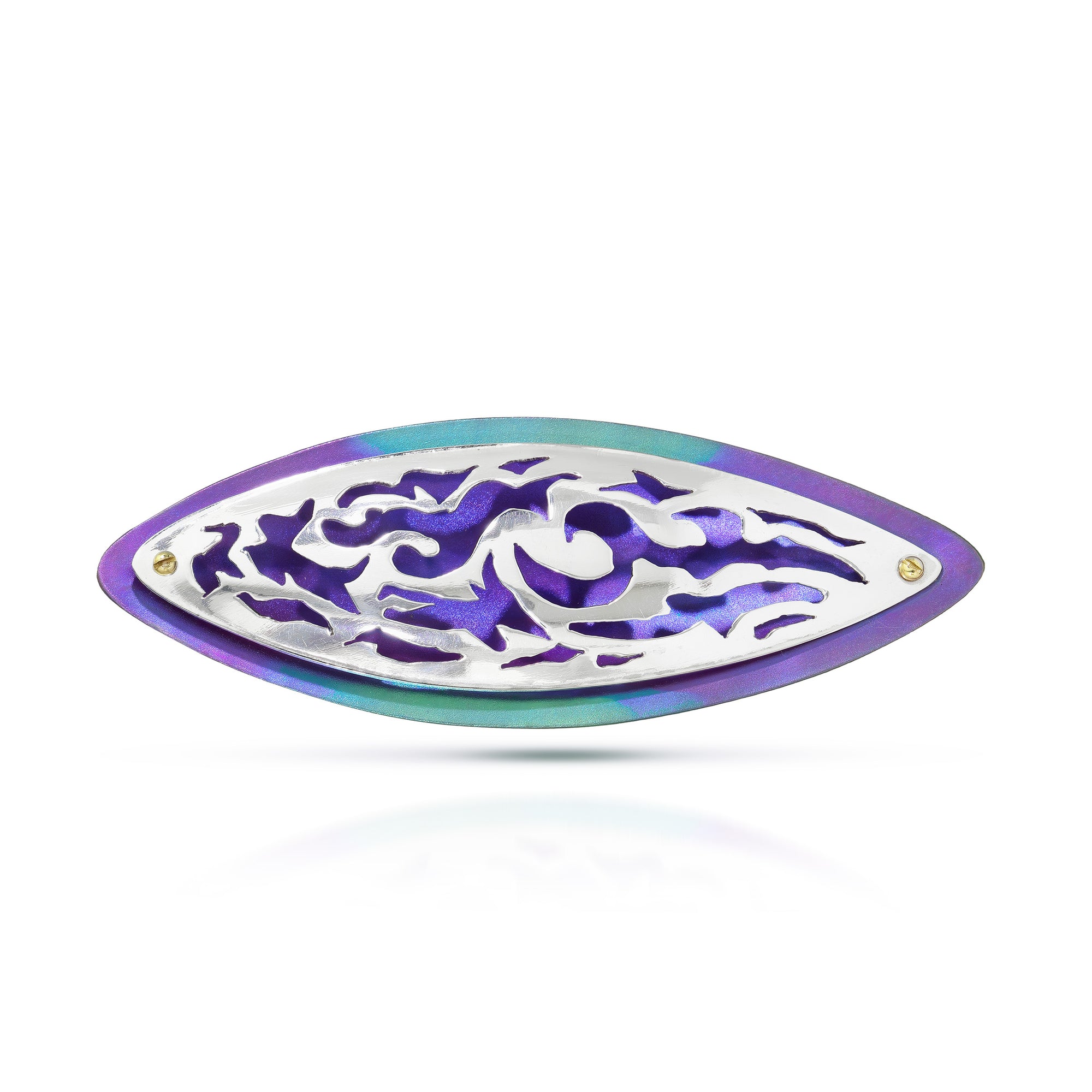 Silver brooch with cut-outs that show a background of the titanium piece of purple and green on a white background